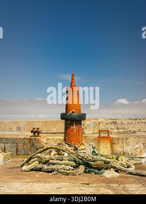 Borne d'amarrage rouillée à John O'Groats avec cordes et pneu Banque D'Images