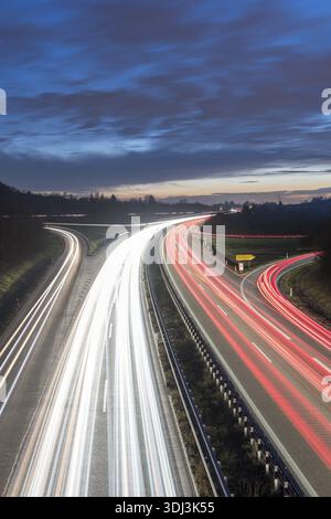 Vue longue exposition d'une autoroute la nuit avec des traînées lumineuses continues sur un ciel bleu, près de Stuttgart, Bade-Wuerttemberg, Allemagne Banque D'Images
