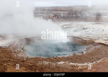 Découvrez la puissance brute de la nature avec cette superbe source thermale géothermique, sur fond de paysage accidenté. La vapeur s'élevant du vib Banque D'Images