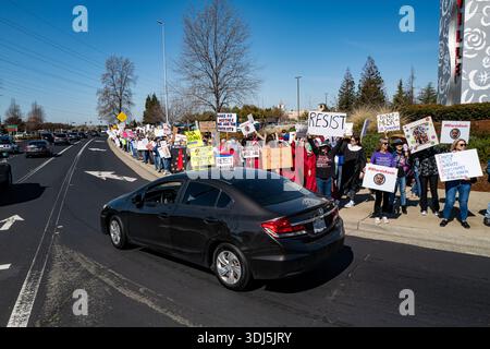 Des manifestants tiennent une pancarte « RESIST » lors d'une manifestation organisée à l'occasion de la Journée internationale de la femme près de la Galleria de Roseville, en Californie. 8 mars 2025. Banque D'Images