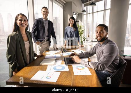 Équipe d'affaires diversifiée de collègues heureux se réunissant à la table de conférence Banque D'Images