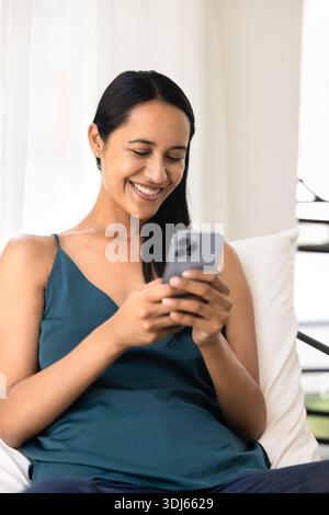 Positive belle Néo-Zélandais utilisateur de smartphone femme tapant du texte Banque D'Images