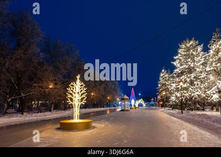 Oulianovsk, Russie - 14 février 2022 : patinoire de rue avec illuminations du nouvel an. Rue enneigée dans les décorations de Noël. Banque D'Images
