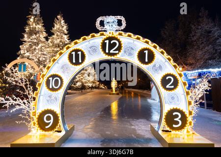Oulianovsk, Russie - 14 février 2022 : énorme horloge de Noël de rue dans l'illumination du soir. Rue enneigée dans les décorations de Noël. Banque D'Images
