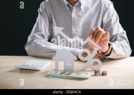 L'investissement immobilier à la maison montre la croissance, la main tient le graphique croissant, maison, symbole de pourcentage, argent, pièces de monnaie, la calculatrice indique l'augmentation de l'immobilier mor Banque D'Images