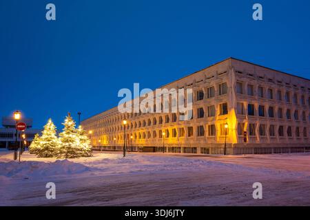 Oulianovsk, Russie - 14 février 2022 : arbres de Noël enneigés décorés de guirlandes, de lampadaires et de l'Université pédagogique d'État d'Oulianovsk. Banque D'Images