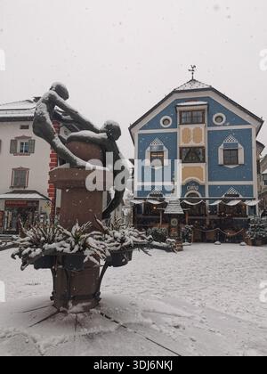 Café Corso, place Saint Antonio et fontaine à Ortisei dans la neige, Dolomites village alpin avec des sommets, paysage de station de ski dans le Tyrol du Sud. Banque D'Images