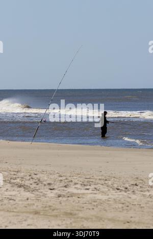 Homme pêchant dans la mer avec canne à pêche sur la plage, Danemark Banque D'Images