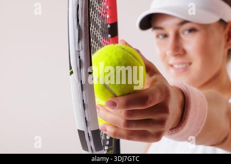 Joueur de tennis tenant la balle et la raquette en gros plan, concentrez-vous sur la main et l'équipement, l'ambiance sportive et énergique. Banque D'Images
