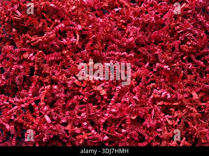 Déchiqueté de papier froissé rouge utilisé pour l'emballage décoratif ou comme matériau de remplissage. Fond rouge parfait pour Noël, Saint-Valentin et autres vacances Banque D'Images