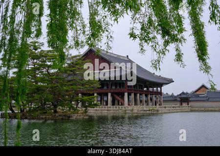 Séoul, Corée du Sud : le pavillon Gyeonghoeru se reflète dans le lac du palais de Gyeongbokgung, entouré de saules et de l'architecture traditionnelle coréenne Banque D'Images