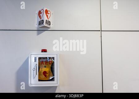 DAE ou défibrillateur externe automatisé installé sur le mur des lieux publics comme premiers secours en situation de crise cardiaque. Avec espace de copie. Banque D'Images