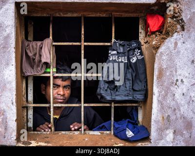 Homme regardant par la fenêtre, Odisha, Inde Banque D'Images