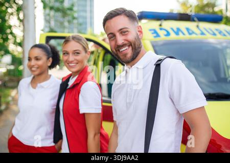 Les paramédicaux multi-ethniques debout au départ d'une ambulance. Médecin urgentiste et infirmier debout devant l'ambulance Banque D'Images