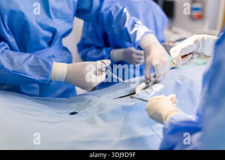 Groupe de chirurgiens pratiquant la chirurgie en salle d'opération hospitalière. Équipe médicale effectuant des opérations critiques. Groupe de chirurgiens en salle d'opération avec chirurgie Banque D'Images