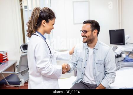 Sourire jeune femme médecin serrer la main Fermer l'affaire d'assurance maladie avec le patient âgé à la consultation à l'hôpital. Joyeuse femme GP poignée de main salutation Banque D'Images
