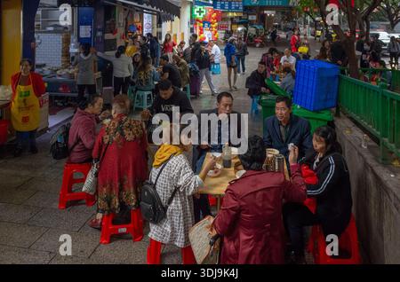 Beaucoup de gens mangent à l'extérieur d'un restaurant dans le quartier peuplé de Jiefangbei . Chongqing, Chine 2019 Banque D'Images