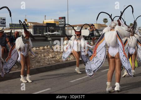Orihuela Costa, Espagne - 17 mars 2024 : défilé de la fête du St.Patrick. Des danseurs en costumes de papillon se produisent dans la rue pendant le festival Banque D'Images