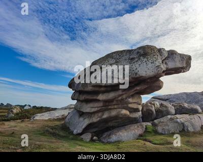 Formation rocheuse sur un terrain herbeux sous un ciel large avec des nuages, paysage naturel avec des paysages extérieurs ouverts. Banque D'Images