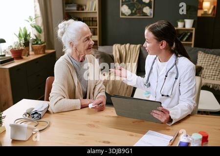 Femme caucasienne senior consultant jeune adulte femme médecin à la maison Banque D'Images