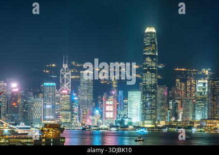 Vue nocturne de Hong Kong avec gratte-ciel illuminés, lumières vibrantes de la ville et reflets sur le port Victoria, en Chine. Ville mondiale, financière Banque D'Images