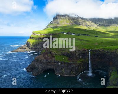 Scène matinale majestueuse de la cascade Mulafossur. Superbe vue estivale sur l'île de Vagar, îles Féroé, Danemark, Europe. Vue depuis le drone volant. Banque D'Images