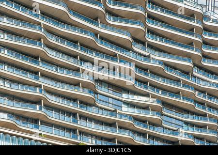 Bâtiment résidentiel moderne avec balcons en verre incurvés, architecture contemporaine et motif géométrique répété dans la ville de Hong Kong, en Chine. Résumé Banque D'Images