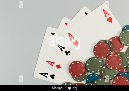 Vue de dessus des cartes à jouer, jetons de poker sur fond gris. Quatre as, jeu de société, poker. Espace de copie, pose à plat. Banque D'Images