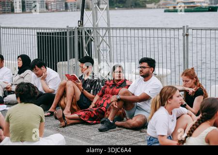 Sydney, Australie. 26 janvier 2026. On voit un homme en train de lire un livre en attendant le feu d'artifice de l'Australia Day. Les gens se rassemblent au Circular Quay Harbour Lookout en attendant le feu d'artifice de l'Australia Day, alors que la foule s'accumule le long du port de Sydney avant les célébrations de la soirée. (Photo de Ye Myo Khant/SOPA images/Sipa USA) crédit : Sipa USA/Alamy Live News Banque D'Images