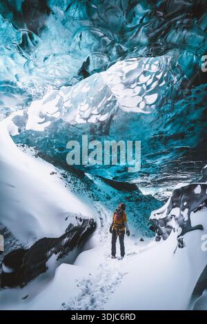Femme regarde le toit de la grotte de glace bleue dans un glacier, Islande Banque D'Images