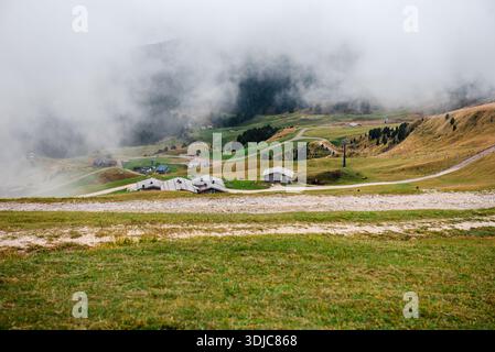 Montagne Seceda avec chalets dispersés et brouillard dans les Dolomites Banque D'Images