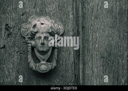 Ancien frappeur de porte sur bois patiné, gros plan noir et blanc. Banque D'Images