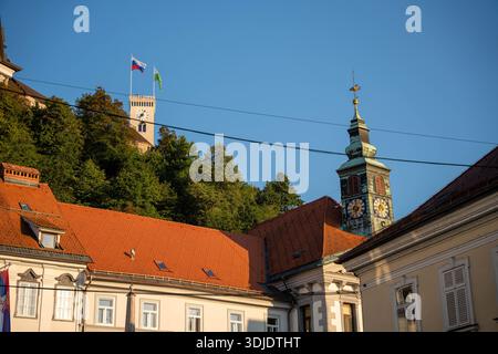 Ljubljana, Slovénie - 10 août 2025 : le château de Ljubljana surplombe le centre historique de la ville, avec sa tour de l'horloge blanche et ses drapeaux visibles au-dessus du R. Banque D'Images