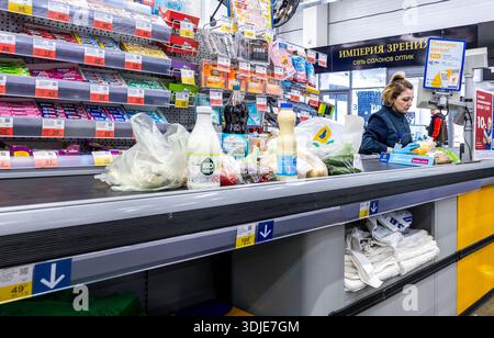 Samara, Russie - 7 avril 2025 : un vendeur sert un client à la caisse dans un super magasin Lenta Banque D'Images