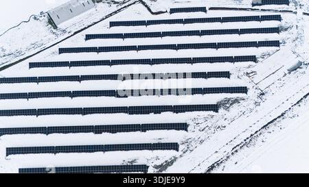 La vue aérienne des panneaux solaires contraste fortement avec le paysage enneigé, un témoignage de l'énergie durable au milieu de l'emprise de l'hiver, Sremska Mitro Banque D'Images