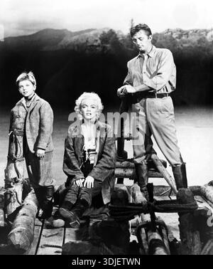Cette photographie vintage en noir et blanc de 1954 montre Tommy Rettig, Marilyn Monroe et Robert Mitchum dans une photo promotionnelle pour le film 'River of No Rettig'. Les acteurs emblématiques sont représentés sur un radeau, suggérant aventure et drame dans le récit du film. Banque D'Images