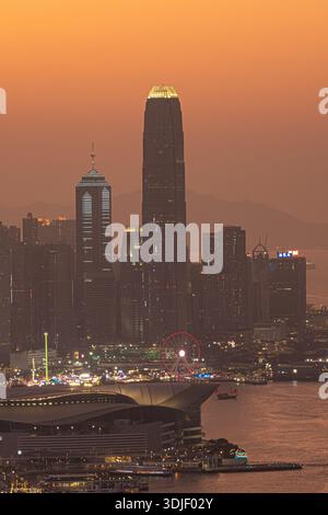 Vue panoramique surélevée sur les gratte-ciel de Hong Kong et le port Victoria au coucher du soleil. Banque D'Images
