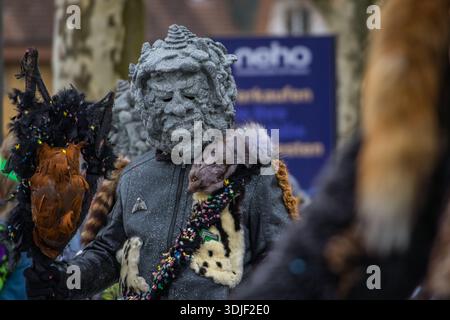 Zug, Suisse - 1er mars 2025 : les participants costumés en tenue de fête et masques célèbrent le défilé du carnaval d'hiver de Fasnacht dans la ville historique Banque D'Images