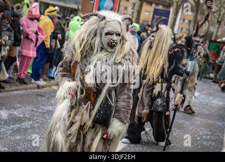 Zug, Suisse - 1er mars 2025 : une personne en costume de bête à fourrure Tschaggatta avec un masque en bois à cornes lors d'un défilé Fasnacht du carnaval d'hiver suisse Banque D'Images