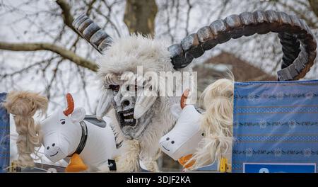 Zug, Suisse - 1er mars 2025 : une personne en costume de bête à fourrure Tschaggatta avec un masque en bois à cornes lors d'un défilé Fasnacht du carnaval d'hiver suisse Banque D'Images