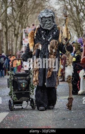Zug, Suisse - 1er mars 2025 : les participants costumés en tenue de fête et masques célèbrent le défilé du carnaval d'hiver de Fasnacht dans la ville historique Banque D'Images