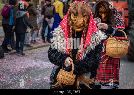 Zug, Suisse - 1er mars 2025 : les participants costumés en tenue de sorcière et masques Larve célèbrent le carnaval d'hiver de Fasnacht lors d'un défilé festif Banque D'Images