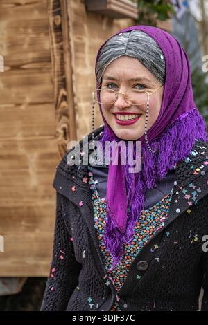 Zug, Suisse - 1er mars 2025 : un participant costumé en tenue festive célèbre le défilé du carnaval d'hiver de Fasnacht dans la ville historique Banque D'Images