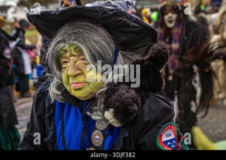 Zug, Suisse - 1er mars 2025 : les participants costumés en tenue de sorcière et masques Larve célèbrent le carnaval d'hiver de Fasnacht lors d'un défilé festif Banque D'Images