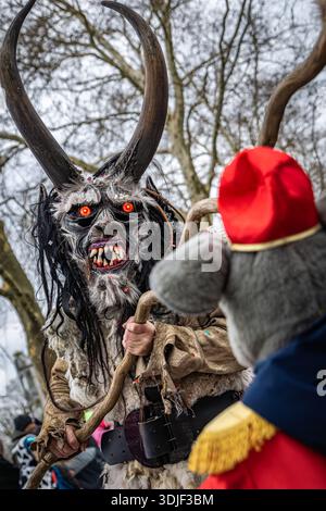 Zug, Suisse - 1er mars 2025 : une personne en costume de bête à fourrure Tschaggatta avec un masque en bois à cornes lors d'un défilé Fasnacht du carnaval d'hiver suisse Banque D'Images