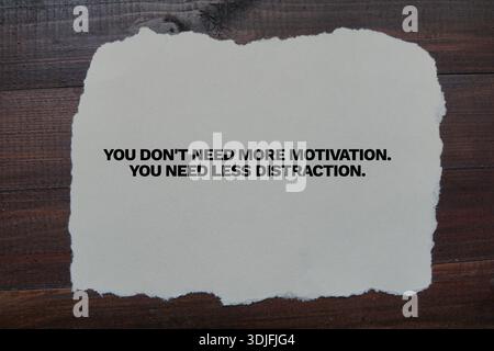 Citation motivante audacieuse sur papier déchiré placé sur une surface en bois, favorisant la concentration et la productivité. Banque D'Images