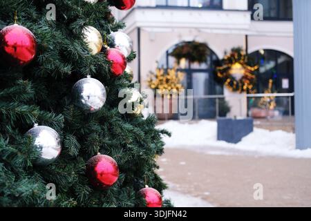 Arbre de Noël décoré avec des ornements brillants se dresse dans un centre commercial, entouré de lumières et de décorations festives, améliorant l'esprit de vacances fo Banque D'Images