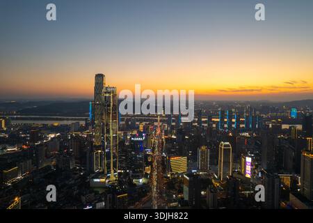 La ville de Changsha en Chine présente un horizon urbain dynamique avec des bâtiments brillants et des lumières du soir sous un magnifique ciel de coucher de soleil. Banque D'Images