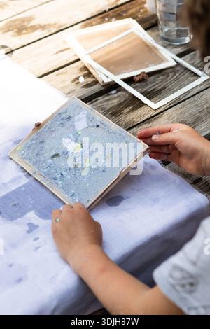 Processus de production de papier recyclé fait main dans un atelier créatif et durable. Banque D'Images