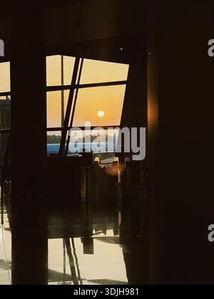 Lumière du coucher du soleil à travers une fenêtre de terminal d'aéroport, Chine Banque D'Images